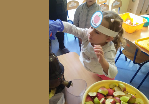 Dzieci wkładają jabłka do wyciskarki